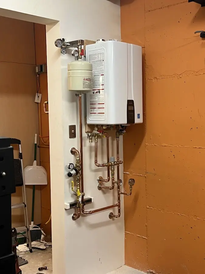 Plumbing technician inspecting water heater connections in Coolbaugh
